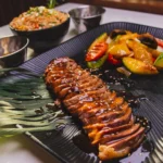 Sliced duck breast with garnish on a plate